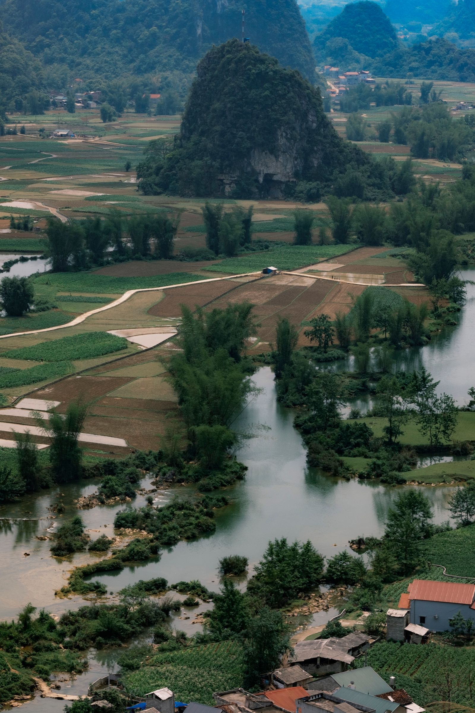 A green river valley winding through cultivated African farmland
